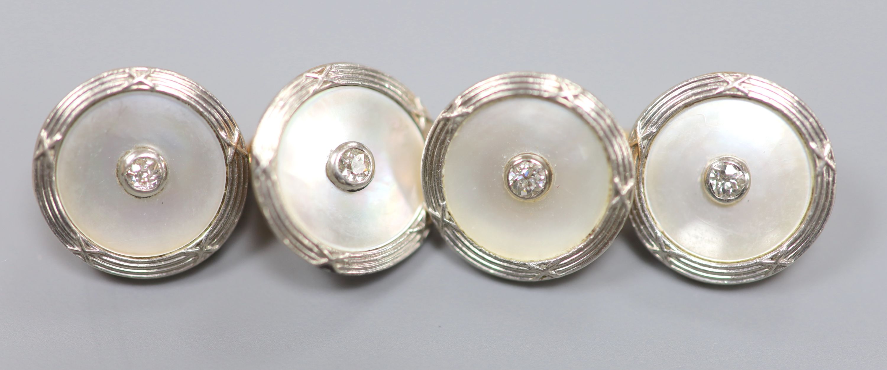 A pair of yellow metal, mother of pearl and diamond disc cufflinks, diameter 14mm, gross weight 8.6 grams.